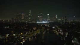 5K aerial stock footage fly over Echo Lake to approach Downtown Los Angeles skyline at night, California Aerial Stock Footage | AX64_0351E