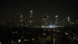 5K aerial stock footage of a view of the Downtown Los Angeles skyline from Echo Lake at night, California Aerial Stock Footage | AX64_0352