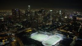 5K aerial stock footage fly over high school sports fields to approach Downtown Los Angeles skyscrapers, California, night Aerial Stock Footage | AX64_0356