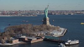 4.8K aerial stock footage of Statue of Liberty with snow coverage on New York Harbor, New York Aerial Stock Footage | AX66_0127E