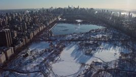 4.8K aerial stock footage of Central Park in snow, tilt to reveal Midtown Manhattan, New York City Aerial Stock Footage | AX66_0196E