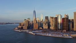 4.8K aerial stock footage reveal One World Trade Center and Battery Park with snow, Lower Manhattan, New York City, sunset Aerial Stock Footage | AX66_0238E