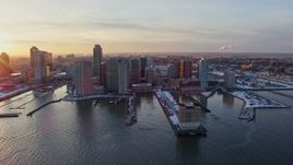 4.8K aerial stock footage of piers with snow and Downtown Jersey City, New Jersey skyscrapers, sunset Aerial Stock Footage | AX66_0245