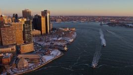 4.8K aerial stock footage of ferries on East River by Battery Park, Lower Manhattan in snow, New York City, sunset Aerial Stock Footage | AX66_0257