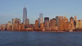 4.8K aerial stock footage tilt from harbor to reveal Lower Manhattan skyline, New York City, sunset Aerial Stock Footage | AX66_0260E