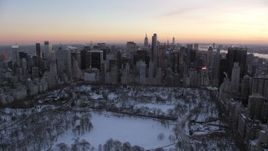 4.8K aerial stock footage of Midtown skyscrapers seen from Central Park in winter, New York City, twilight Aerial Stock Footage | AX66_0306