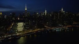 4.8K aerial stock footage of passing Midtown Manhattan skyscrapers and United Nations building, New York City, night Aerial Stock Footage | AX66_0415E