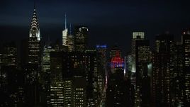 4.8K aerial stock footage of Chrysler Building, city canyons and the Empire State Building in Midtown Manhattan, New York City, night Aerial Stock Footage | AX66_0443E