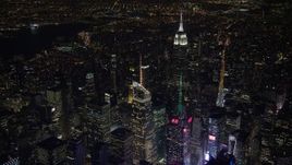 4.8K aerial stock footage view orbit Bank of America Tower in Midtown Manhattan at night, reveal Empire State Building, New York Aerial Stock Footage | AX67_0041