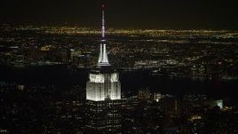4.8K aerial stock footage view of the Empire State Building with Hudson River in the background at night, Midtown Manhattan, New York City, New York Aerial Stock Footage | AX67_0046