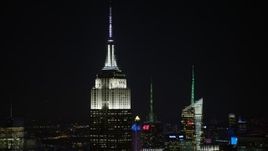 4.8K aerial stock footage view of the top of Empire State Building at night, Midtown Manhattan, New York City, New York Aerial Stock Footage | AX67_0048