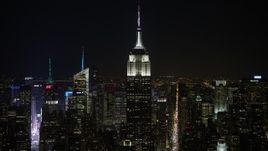 4.8K aerial stock footage view of the Empire State Building and Midtown skyscrapers at night, Midtown Manhattan, New York City, New York Aerial Stock Footage | AX67_0049