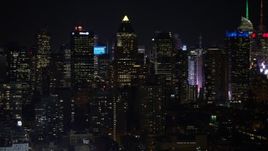 4.8K aerial stock footage view of panning across and passing Midtown Manhattan skyscrapers at night, New York Aerial Stock Footage | AX67_0058