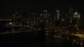 4.8K aerial stock footage view approach the Brooklyn Bridge and Lower Manhattan skyline at night, New York Aerial Stock Footage | AX67_0081