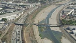 4.8K aerial stock footage of light Traffic on I-710 by between warehouse buildings and the Los Angeles River in Vernon, Los Angeles, California Aerial Stock Footage | AX68_037