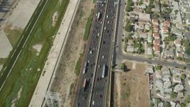 4.8K aerial stock footage of reverse bird's eye view of light traffic on Interstate 710 through Bell Gardens, Los Angeles, California Aerial Stock Footage | AX68_042
