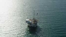 4.8K aerial stock footage of an oil drilling platform near sunlight reflected off the ocean near Long Beach, California Aerial Stock Footage | AX68_107