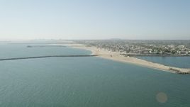 4.8K aerial stock footage approach the breakwater, pier, beach and coastal neighborhoods in Seal Beach, California Aerial Stock Footage | AX68_121