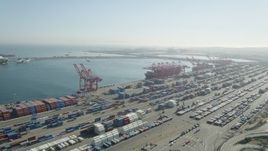 4.8K aerial stock footage of cargo containers and ships under cranes at the Port of Long Beach, California Aerial Stock Footage | AX68_142