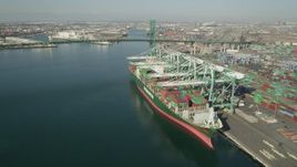 4.8K aerial stock footage flyby docked cargo ship to approach Vincent Thomas Bridge at Port of Los Angeles, California Aerial Stock Footage | AX68_163