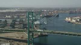 4.8K aerial stock footage fly over Vincent Thomas Bridge to approach cranes at the Port of Los Angeles, California Aerial Stock Footage | AX68_164