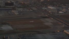 4.8K aerial stock footage of tracking an airliner landing on a runway at LAX Airport at sunset, California Aerial Stock Footage | AX69_004