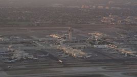 4.8K aerial stock footage of LAX control tower and terminals as airliner lands at sunset, Los Angeles, California Aerial Stock Footage | AX69_008