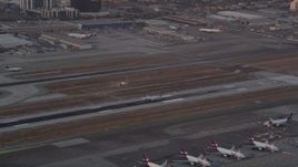 4.8K aerial stock footage track passenger jet landing on runway at sunset at LAX, Los Angeles, California Aerial Stock Footage | AX69_014