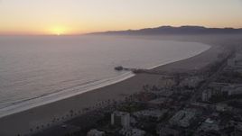 4.8K aerial stock footage of the Santa Monica Pier with the sun setting in the horizon, California Aerial Stock Footage | AX69_030