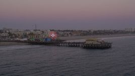 4.8K aerial stock footage orbit and fly away from the end of Santa Monica Pier at twilight, California Aerial Stock Footage | AX69_036