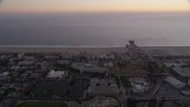4.8K aerial stock footage orbit buildings by the beach and Santa Monica Pier at twilight, California Aerial Stock Footage | AX69_039