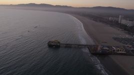 4.8K aerial stock footage of the end of Santa Monica Pier, Pacific Wheel, and the beach at twilight, California Aerial Stock Footage | AX69_042