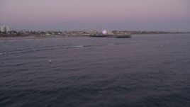 4.8K aerial stock footage tilt from the ocean to reveal and approach Santa Monica Pier at twilight, California Aerial Stock Footage | AX69_046