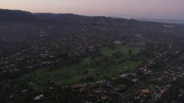 4.8K aerial stock footage tilt to golf course ringed by mansions at twilight in Pacific Palisades, California Aerial Stock Footage | AX69_049