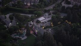 An orbit around The Playboy Mansion at twilight in Los Angeles, California Aerial Stock Footage | AX69_064