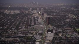 4.8K aerial stock footage tilt from Wilshire Boulevard in Beverly Hills to reveal Downtown Los Angeles, California, twilight Aerial Stock Footage | AX69_069