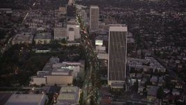 4.8K aerial stock footage tilt from Wilshire Boulevard in Beverly Hills to reveal Downtown Los Angeles Skyline at twilight, California Aerial Stock Footage | AX69_072