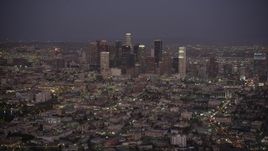 4.8K aerial stock footage tilt from apartment buildings and city street to reveal Downtown Los Angeles skyline at night, California Aerial Stock Footage | AX69_077