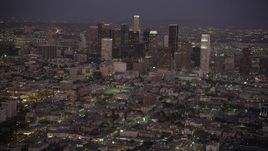 4.8K aerial stock footage tilt from urban streets and apartments to reveal and approach the Downtown Los Angeles skyline at night, California Aerial Stock Footage | AX69_078