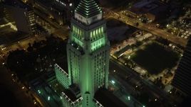 4.8K aerial stock footage tilt from street to reveal Los Angeles City Hall in Downtown Los Angeles at night, California Aerial Stock Footage | AX69_086