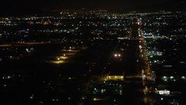 4.8K aerial stock footage of small airplane landing at Whiteman Airport at night in Pacoima, California Aerial Stock Footage | AX69_158