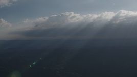4K aerial stock footage Rays of sunshine shining on mountains from clouds over San Luis Obispo County, California Aerial Stock Footage | AX70_081