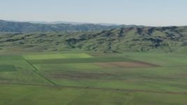 4K aerial stock footage Farm fields beside green hills in Hollister, California Aerial Stock Footage | AX70_108