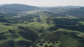 4K aerial stock footage Green hills around a country road leading to a small ranch in Paicines, California Aerial Stock Footage | AX70_162