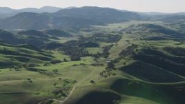 4K aerial stock footage Flyby a country road leading to a small ranch, surrounded by green hills in Paicines, California Aerial Stock Footage | AX70_163