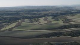 4K aerial stock footage Flying over green hills with plowed areas in San Benito County, California Aerial Stock Footage | AX70_173