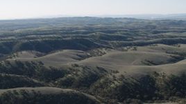 4K aerial stock footage Flying over green hills and dirt roads in San Benito County, California Aerial Stock Footage | AX70_175