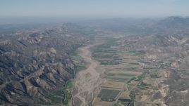 4K aerial stock footage Farm fields and Santa Clara River bordered by mountains in Piru, California Aerial Stock Footage | AX70_183