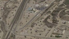 4K aerial stock footage Bird's eye of working oil rigs beside railroad tracks in San Ardo, California Aerial Stock Footage | AX70_237