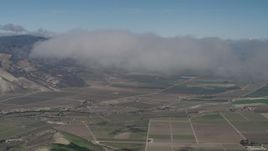 4K aerial stock footage of An approach to a cloud over farm fields in Greenfield, California Aerial Stock Footage | AX70_243